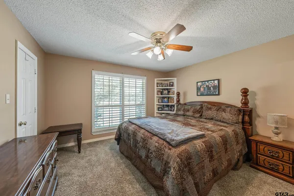 a spacious bedroom with a large bed and a chandelier