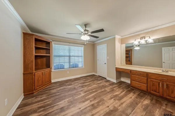 a view of an empty room with a window and a kitchen