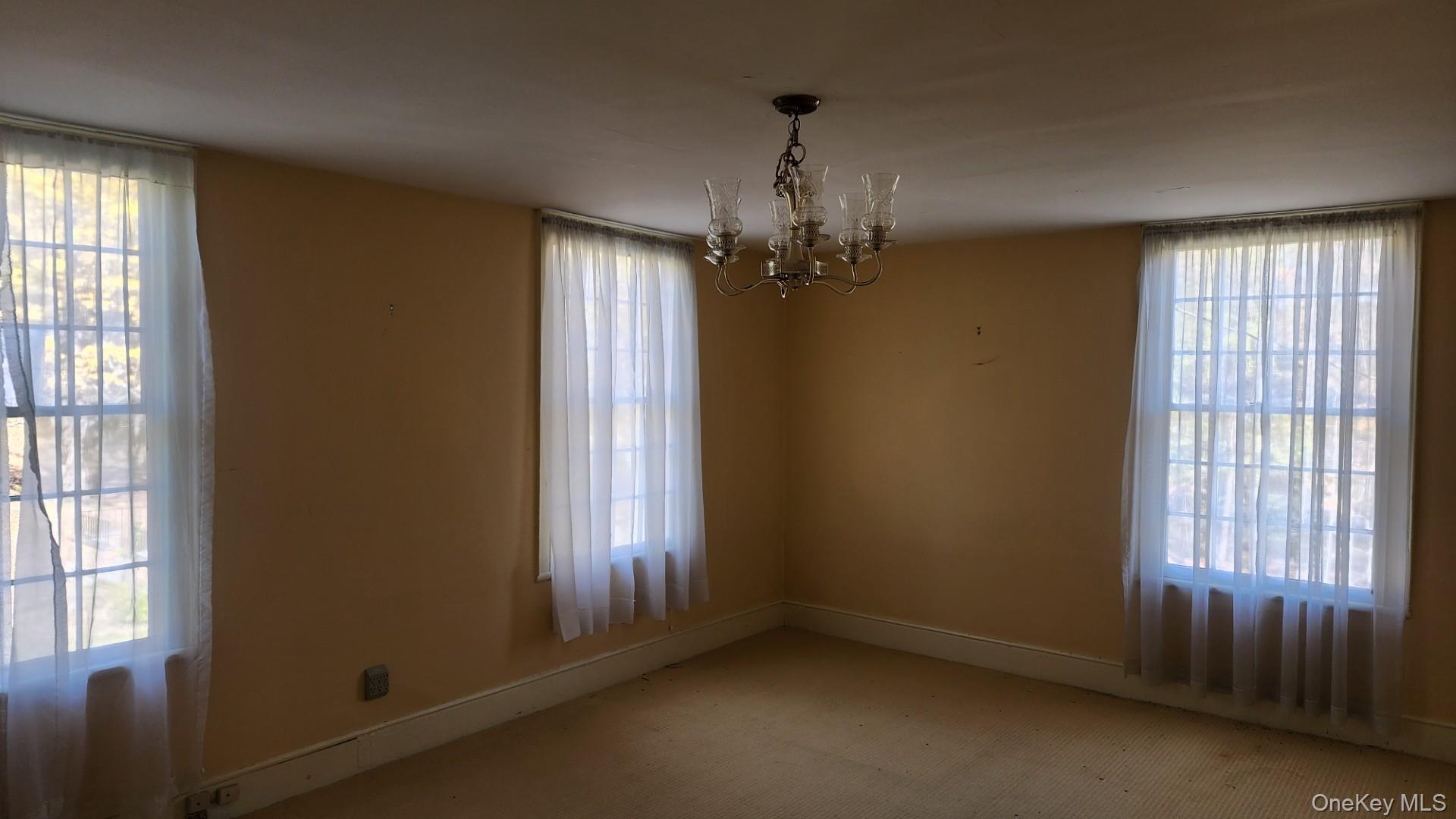 175 Waccabuc Road Goldens Bridge, NY 10526 - Photo 14 of 36 Unfurnished dining area with a chandelier, plenty of natural light, and carpet floors