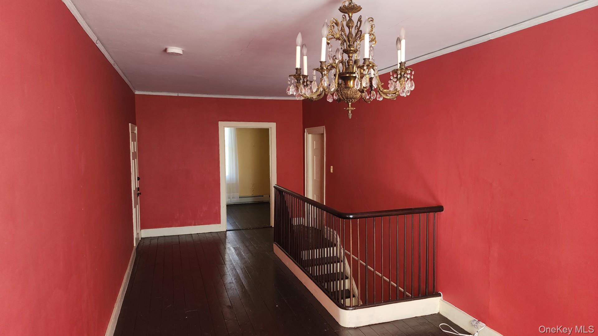 175 Waccabuc Road Goldens Bridge, NY 10526 - Photo 21 of 36 Stairway featuring crown molding, hardwood / wood-style floors, a chandelier, and a baseboard radiator