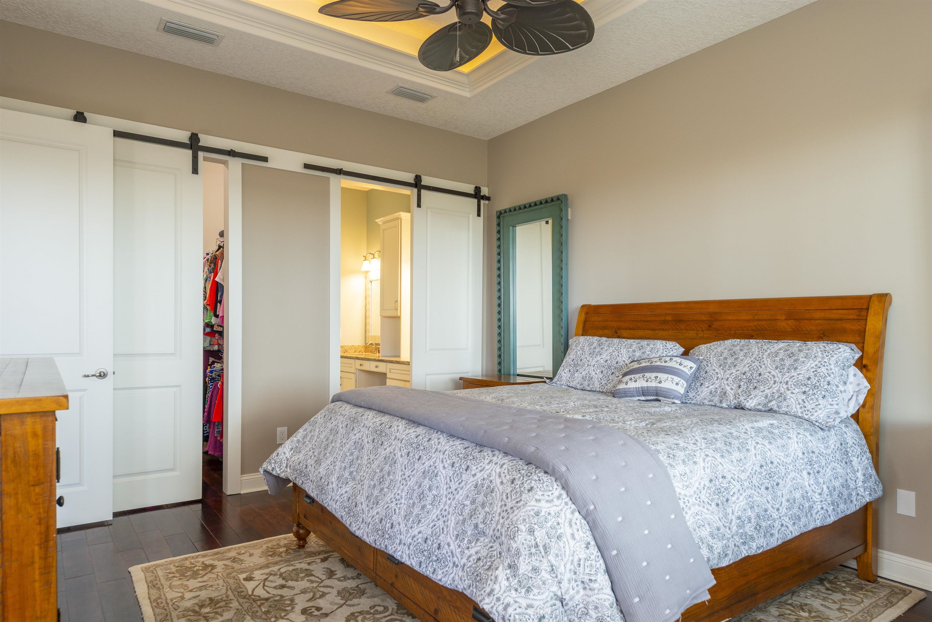 5475 Riverwood Road North St. Augustine, FL 32092 - Photo 14 of 62 Bedroom with a spacious closet, dark wood-style floors, a textured ceiling, ensuite bath, and ceiling fan