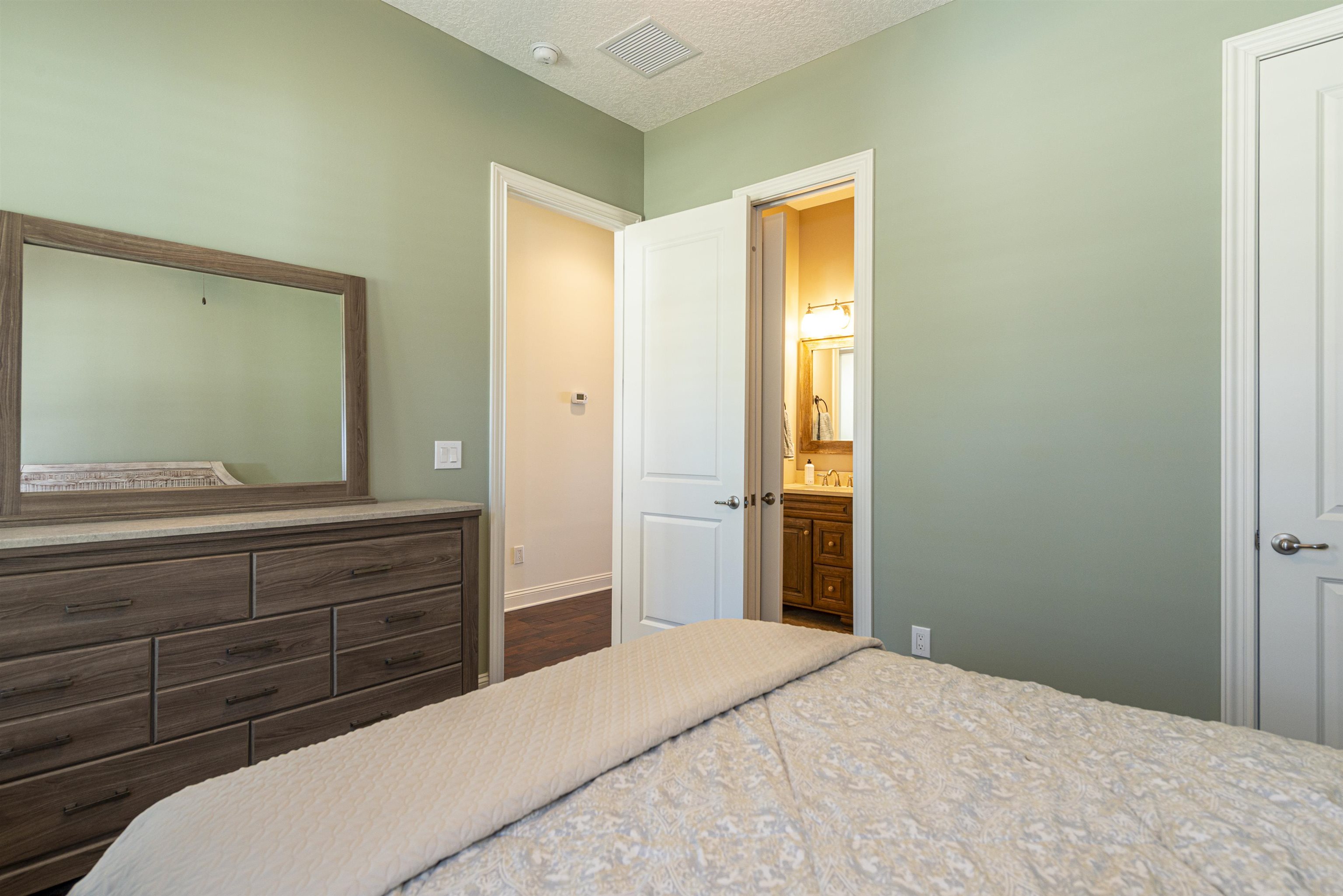 5475 Riverwood Road North St. Augustine, FL 32092 - Photo 21 of 62 Bedroom with a textured ceiling and connected bathroom