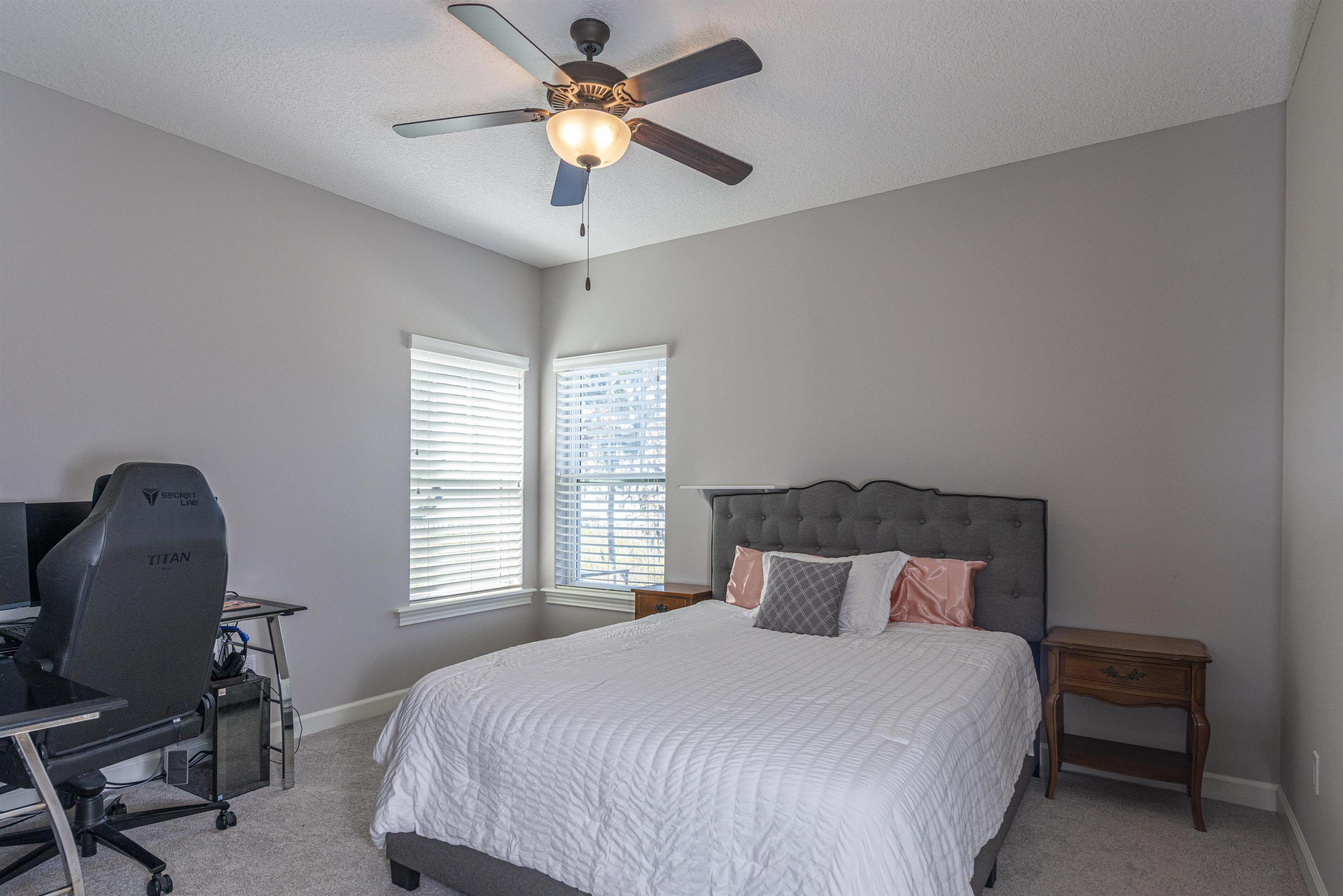 5475 Riverwood Road North St. Augustine, FL 32092 - Photo 27 of 62 Bedroom with an office area, light carpet, a ceiling fan, and a textured ceiling