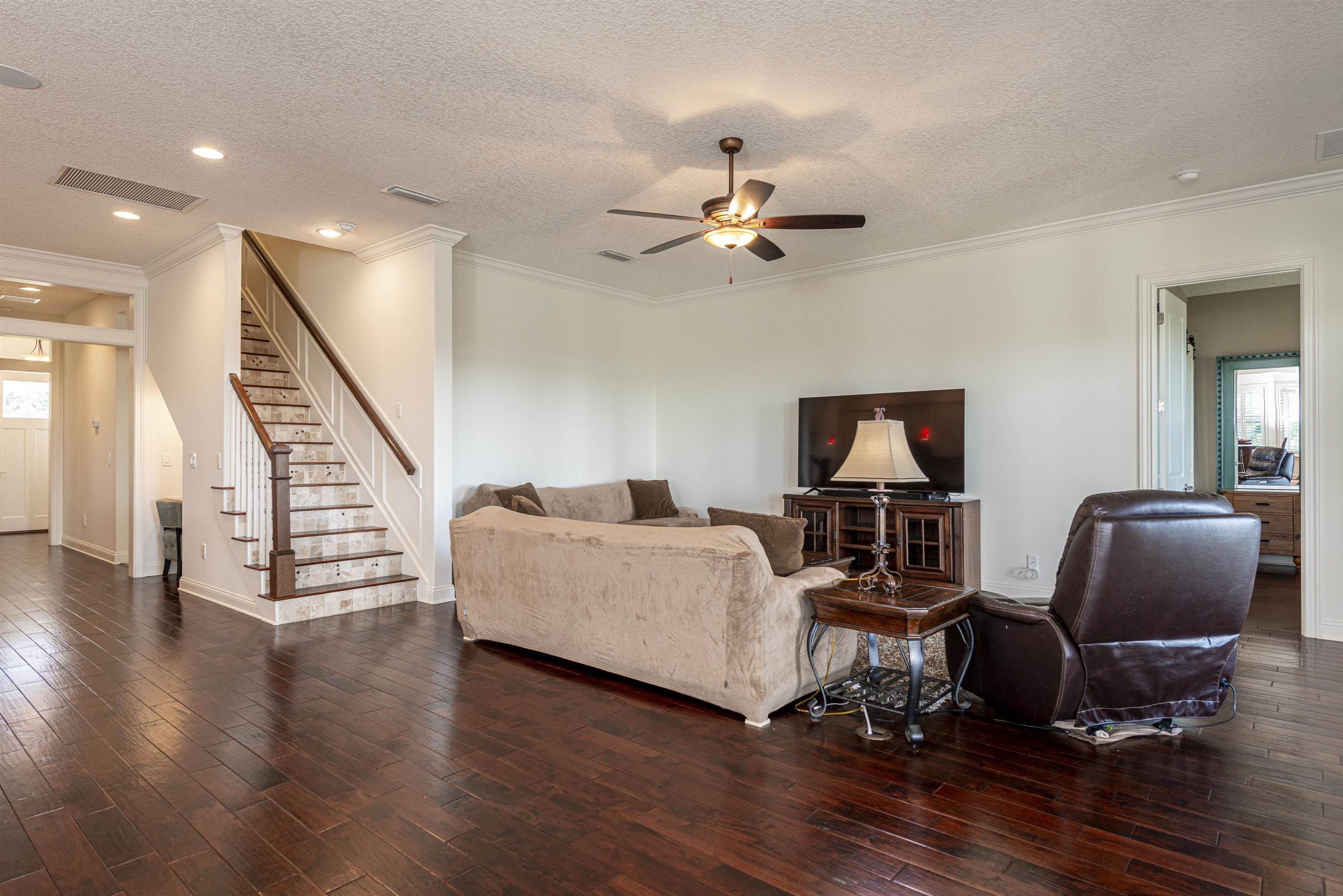 5475 Riverwood Road North St. Augustine, FL 32092 - Photo 4 of 62 Living area with stairs, plenty of natural light, dark wood-style flooring, a textured ceiling, and crown molding
