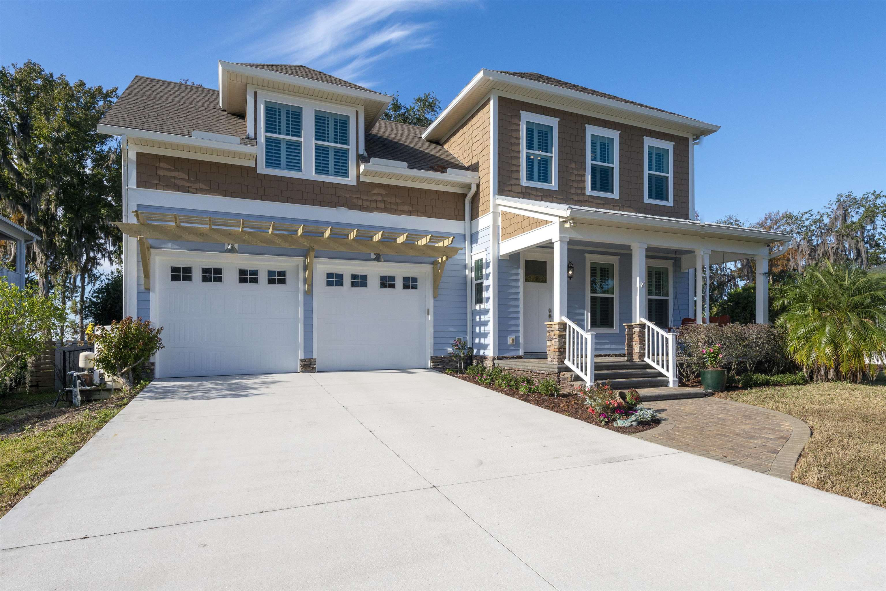 5475 Riverwood Road North St. Augustine, FL 32092 - Photo 52 of 62 View of front of house featuring concrete driveway, a porch, a garage, and roof with shingles