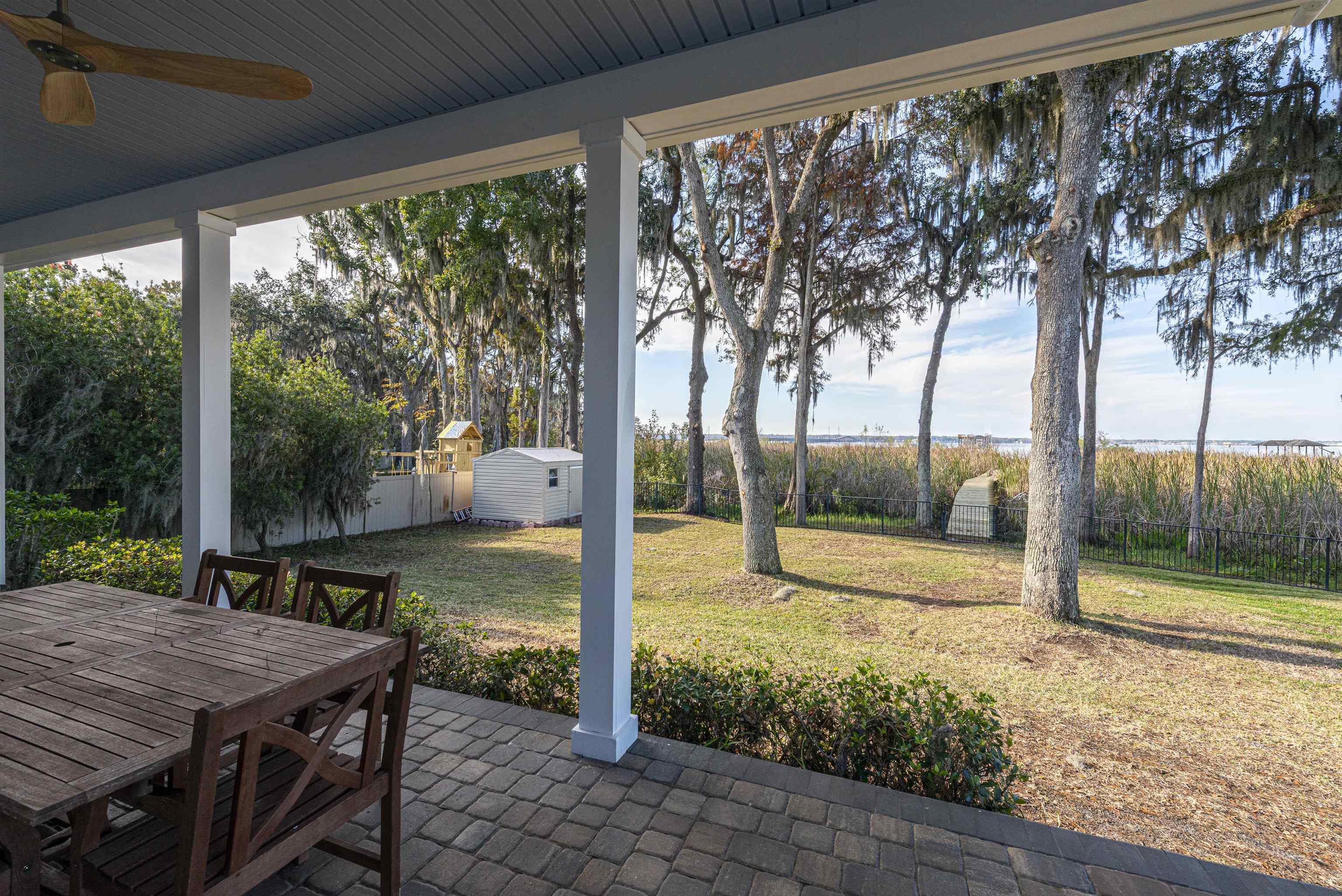 5475 Riverwood Road North St. Augustine, FL 32092 - Photo 53 of 62 Fenced backyard with a patio, outdoor dining space, ceiling fan, and a storage unit
