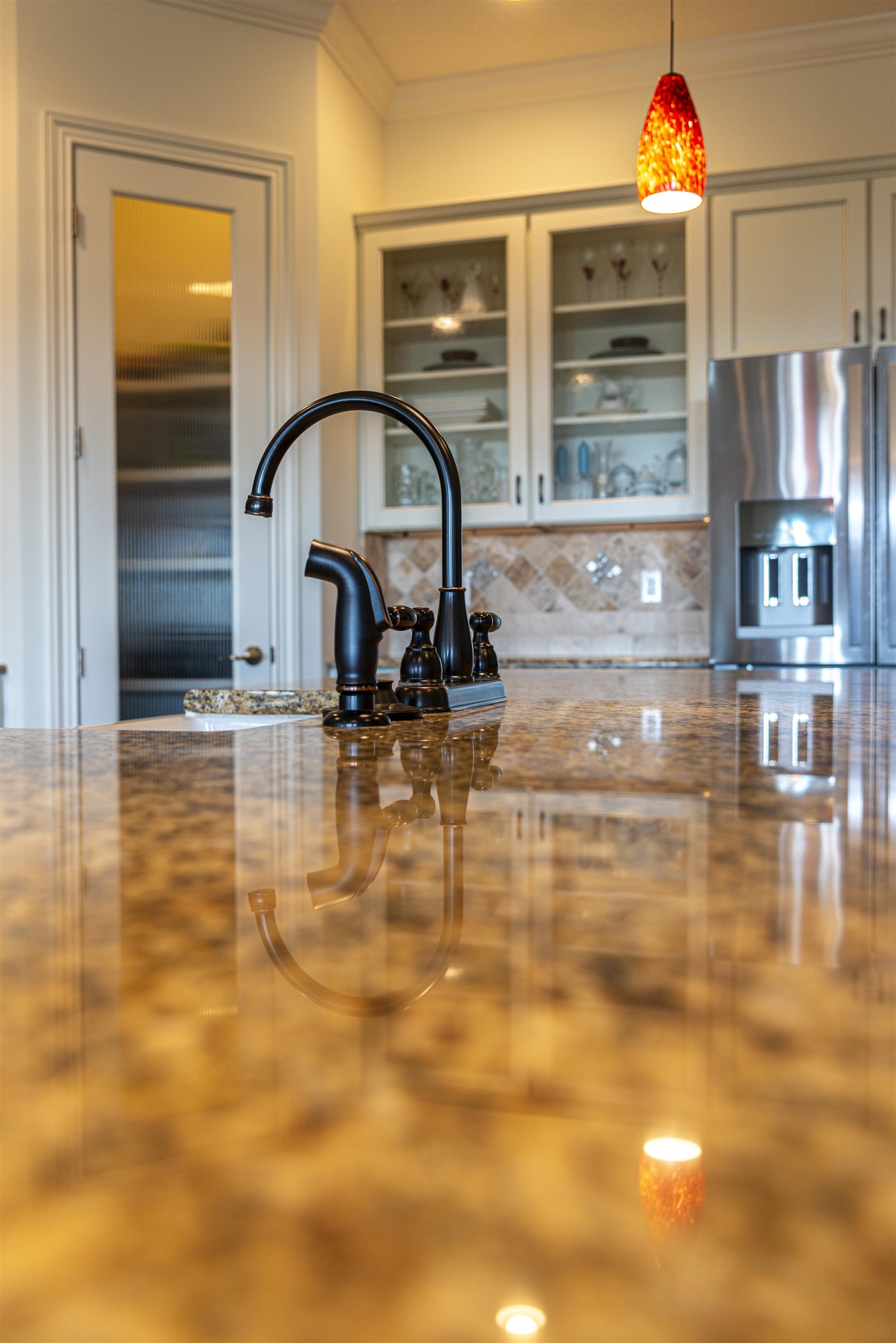 5475 Riverwood Road North St. Augustine, FL 32092 - Photo 8 of 62 Kitchen view of hanging light fixtures, stainless steel fridge, crown molding, dark stone counters, and backsplash