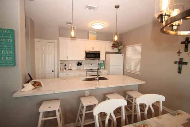 a bedroom with a bed and a lamp on dresser