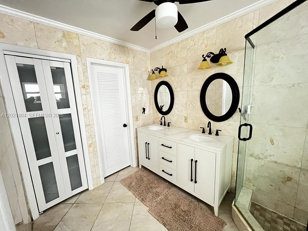 3324 Lakeview Boulevard Delray Beach, FL 33445 - Photo 21 of 36 a bathroom with double vanity sink and a mirror