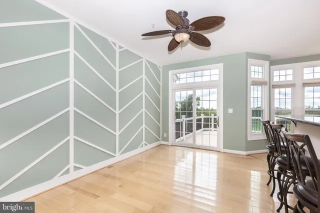 a view of a livingroom with furniture wooden floor and a ceiling fan