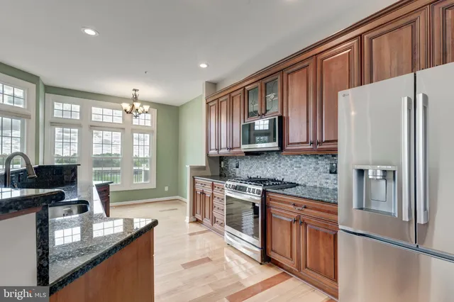 a kitchen with stainless steel appliances granite countertop a refrigerator stove microwave and sink