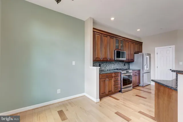 a kitchen with stainless steel appliances granite countertop a stove top oven a sink and dishwasher