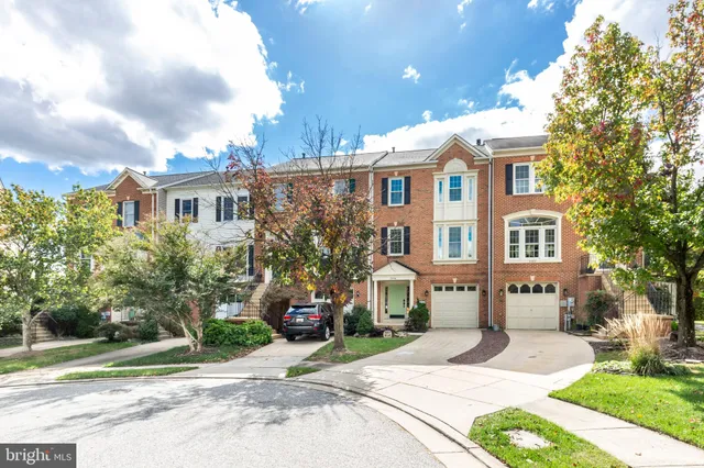 a front view of a house with a garden and tree