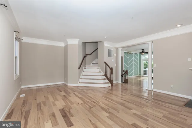 a view of a hallway with wooden floors and white walls
