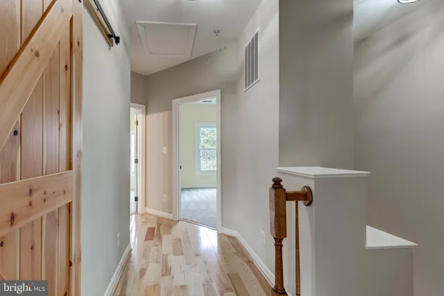 a view of a hallway with wooden floor and staircase