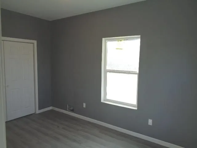 an empty room with wooden floor and a window