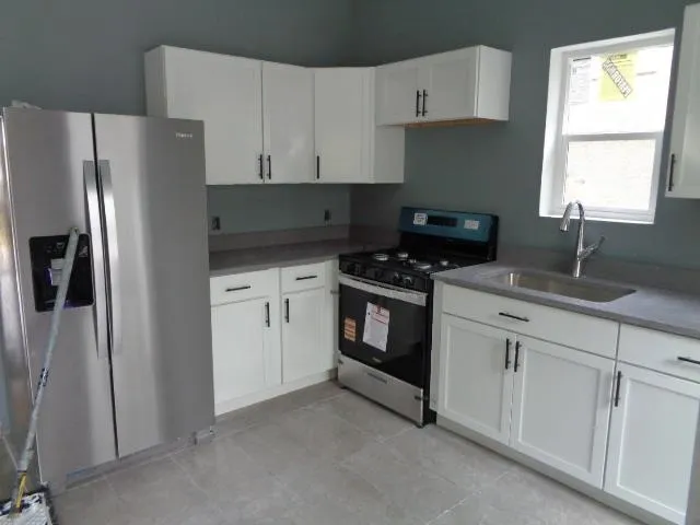 a kitchen with white cabinets and white appliances