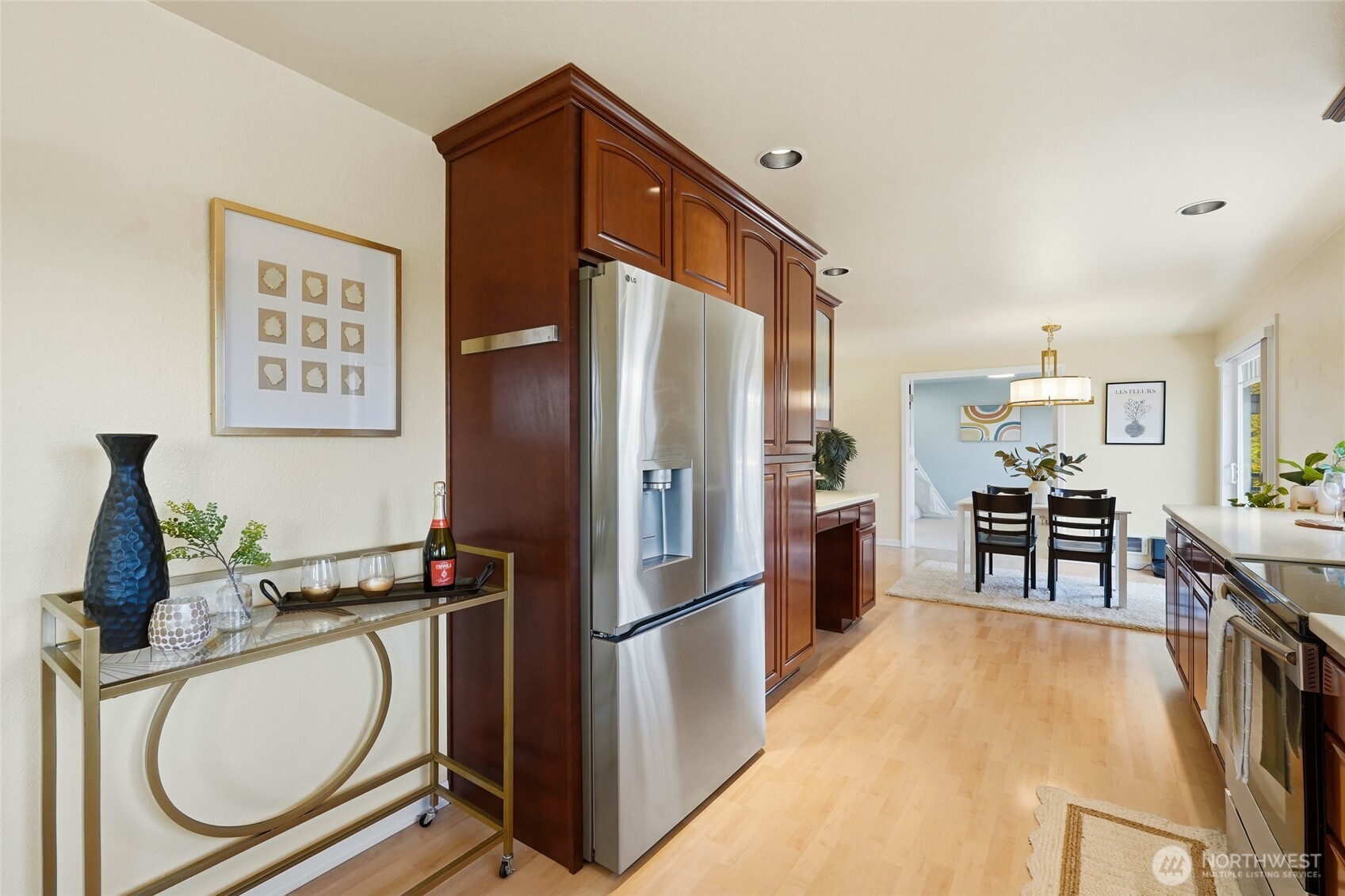 7503 212th Street Southwest, Unit B302 Edmonds, WA 98026 - Photo 13 of 28 a kitchen with stainless steel appliances granite countertop a refrigerator a stove and a dining table with wooden floor