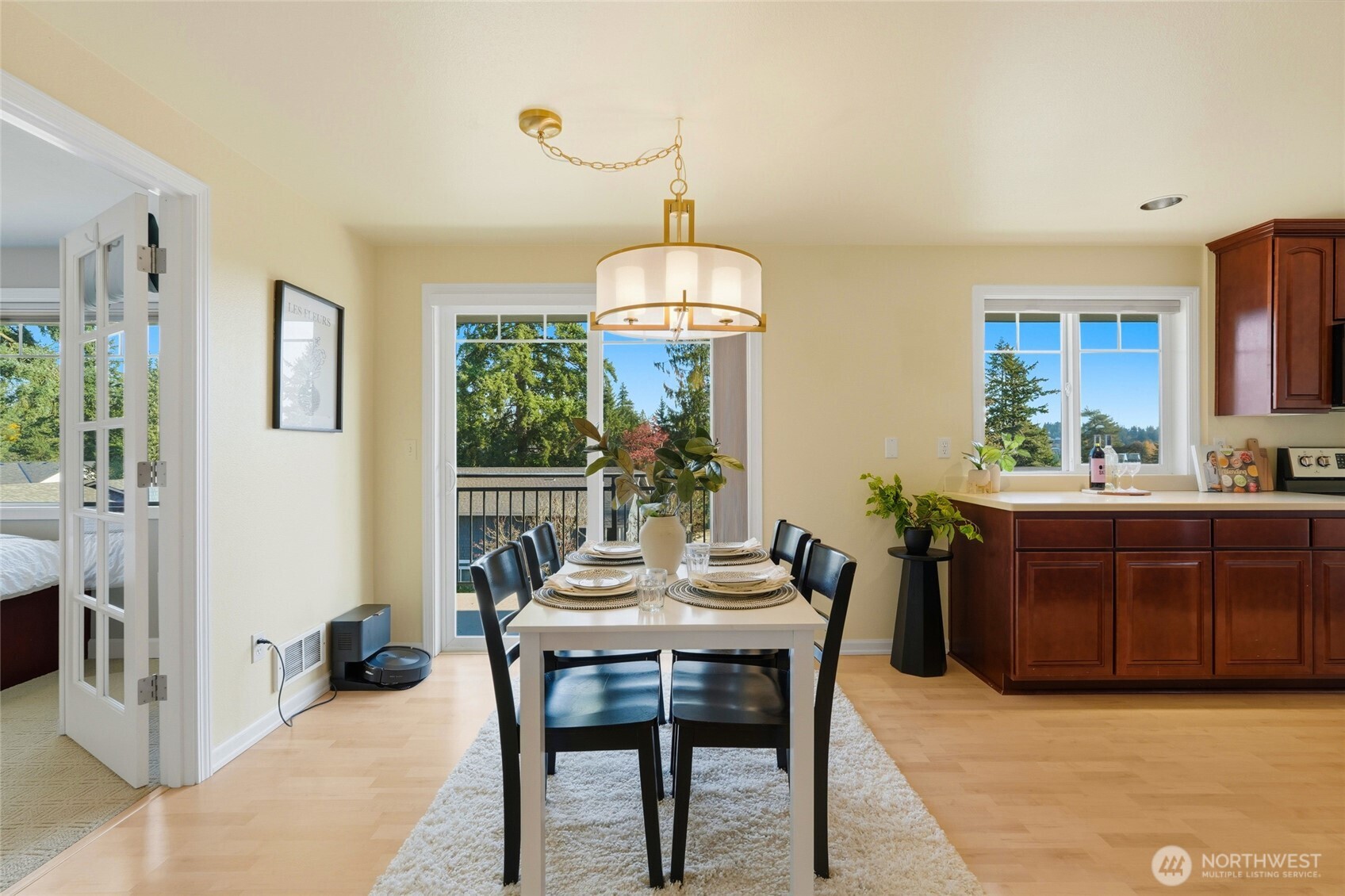 7503 212th Street Southwest, Unit B302 Edmonds, WA 98026 - Photo 16 of 28 a dining room with wooden floor a chandelier a wooden table and chairs