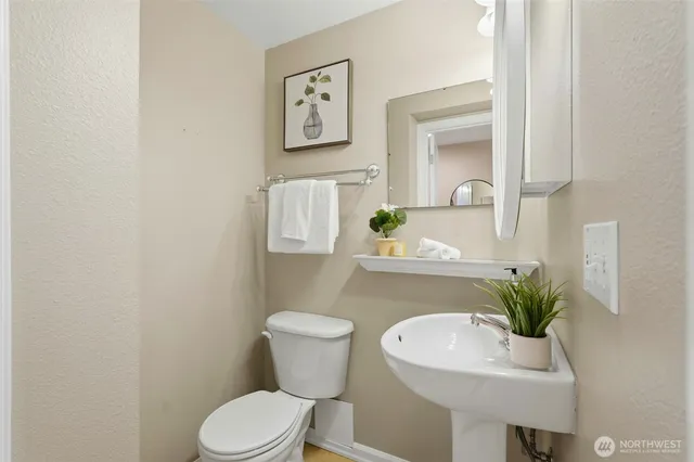 a bathroom with a toilet a sink and mirror