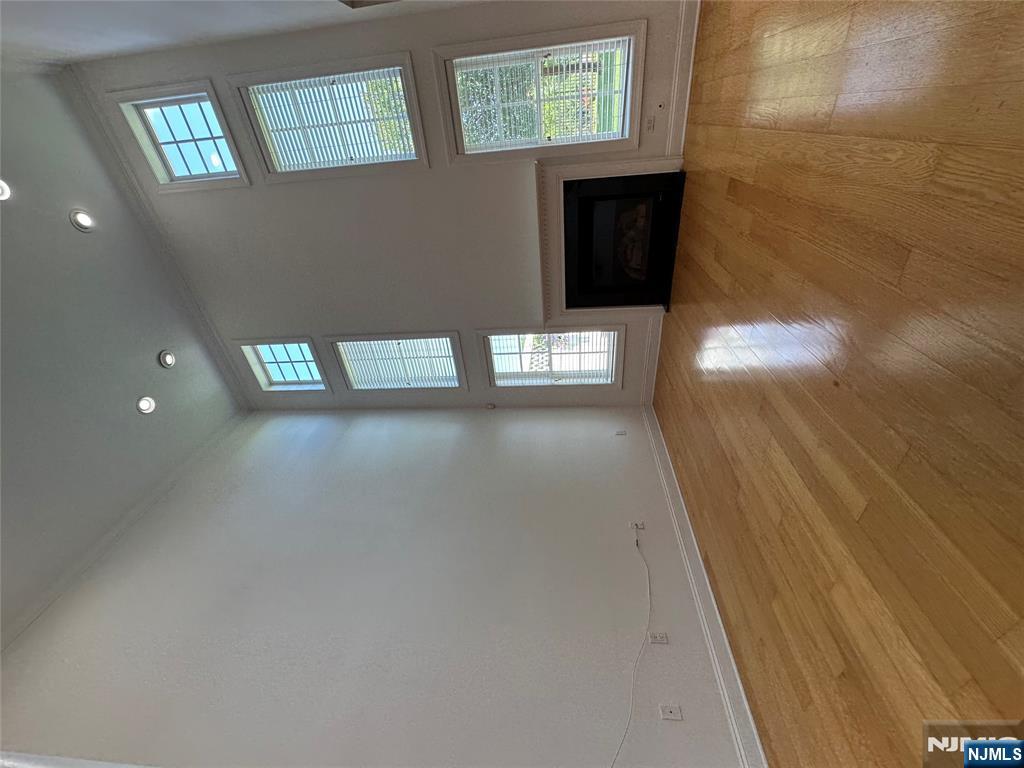 35 Magnolia Way North Haledon, NJ 07508 - Photo 8 of 40 an empty room with wooden floor fireplace and windows