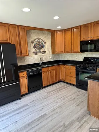 a kitchen with granite countertop wooden cabinets and a stove top oven