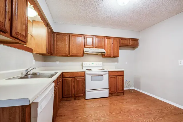 a kitchen with stainless steel appliances granite countertop a sink a stove and a refrigerator