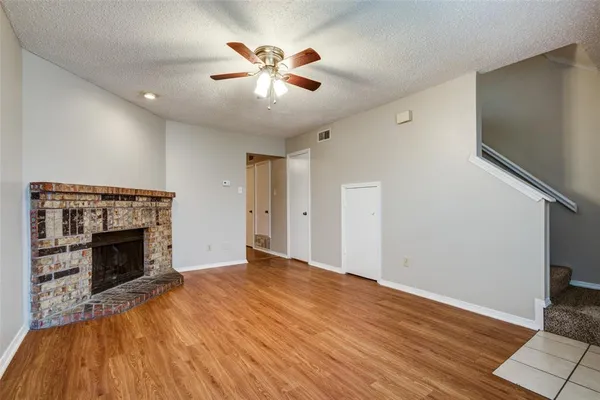 a view of empty room with wooden floor and fireplace