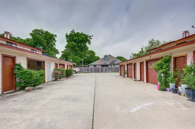 a front view of a house with a yard and potted plants