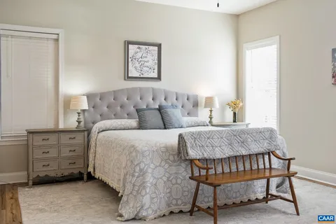 a bedroom with bed tv and table