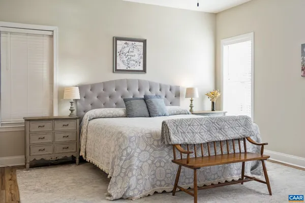 a bedroom with bed tv and table