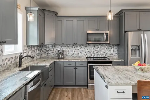 a kitchen with kitchen island granite countertop a sink stove and refrigerator