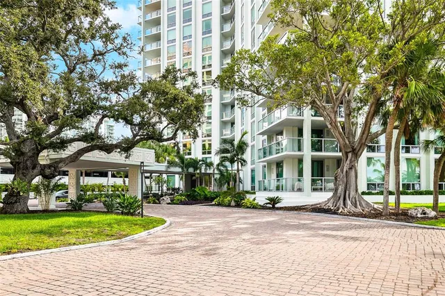 a front view of a building with a garden and plants