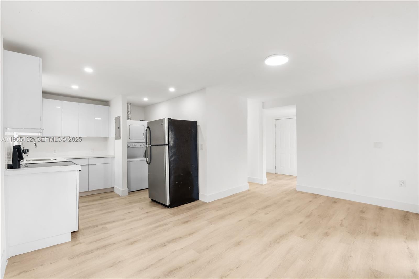 a view of a kitchen with a sink and a refrigerator