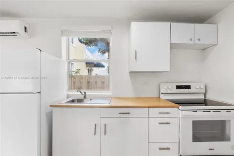 a kitchen with a sink a stove and white cabinets
