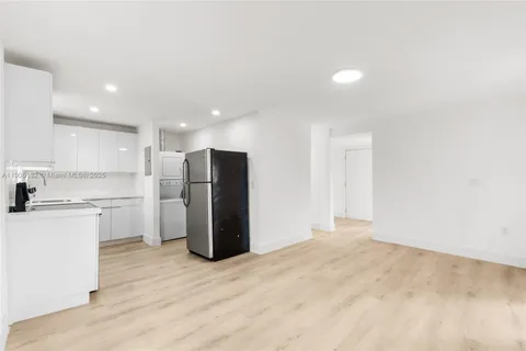 a view of a kitchen with a sink and a refrigerator