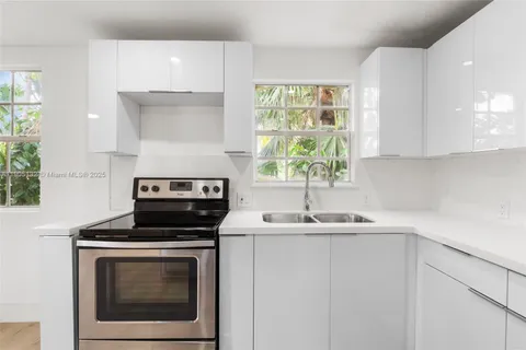a kitchen with a sink stove and cabinets