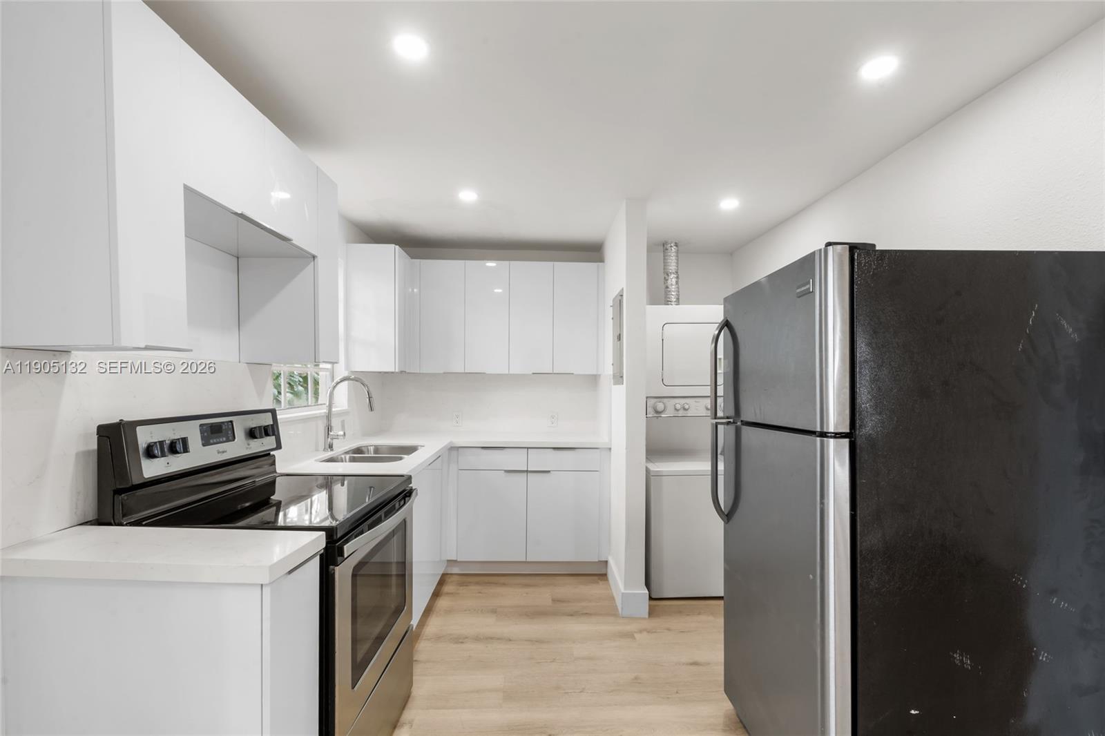 2385 Southwest 17th Street Miami, FL 33145 - Photo 8 of 28 a kitchen with a refrigerator a stove top oven and cabinets