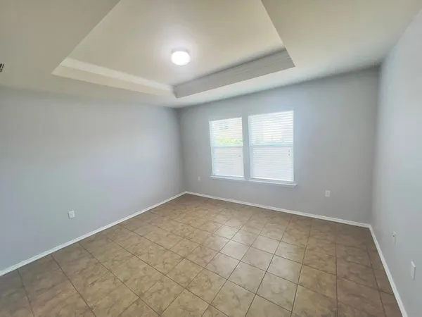 an empty room with a white cabinet and windows