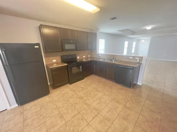 a kitchen with granite countertop a refrigerator and a sink