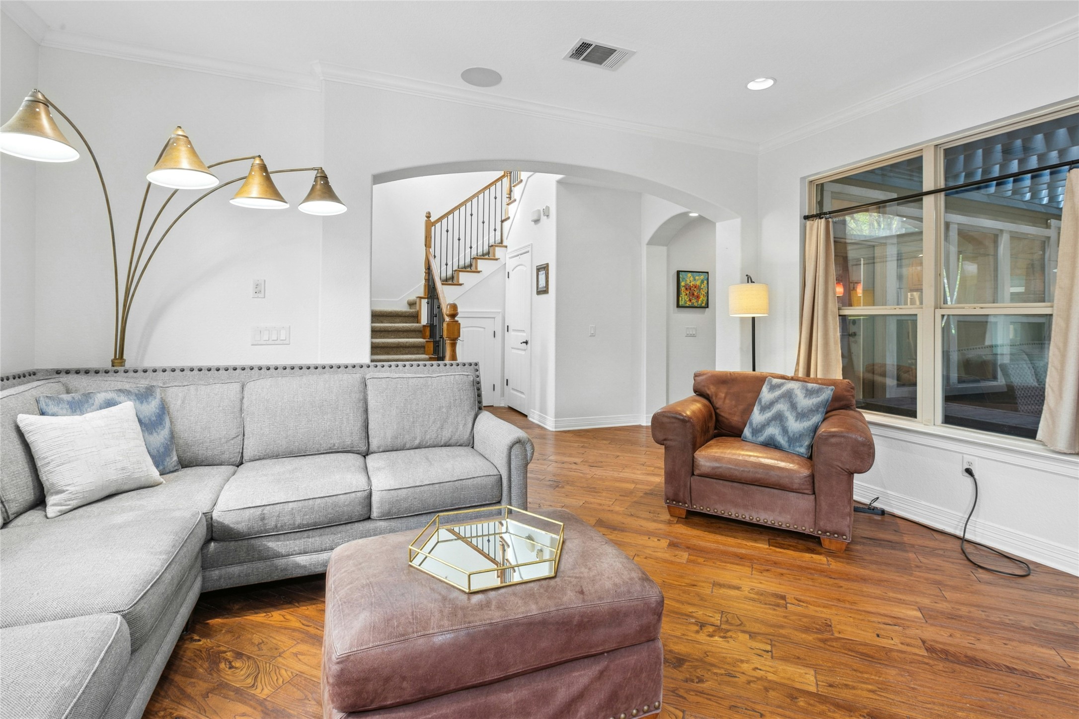 1912 Antone Street Austin, TX 78723 - Photo 6 of 38 Living area featuring wood-type flooring, crown molding, stairway, and arched walkways