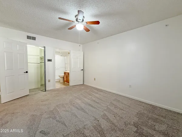 an empty room with closet and fan
