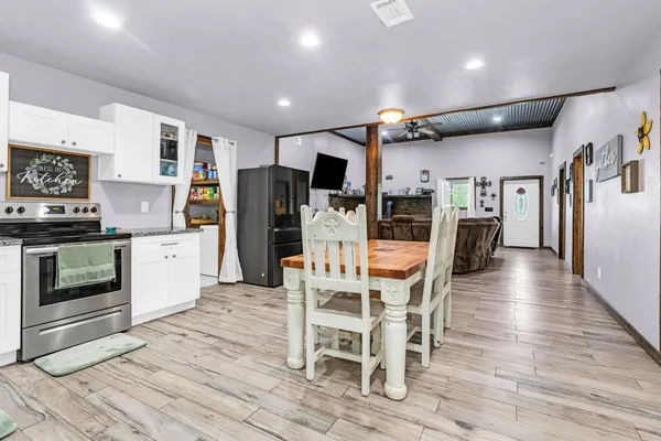 a kitchen with stainless steel appliances kitchen island granite countertop a refrigerator and a stove top oven