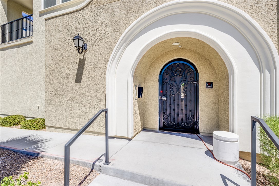 2555 Hampton Road, Unit 8206 Henderson, NV 89052 - Photo 24 of 25 Ornate ironwork adorns the entrance, framed by an elegant arched doorway leading into the residence.