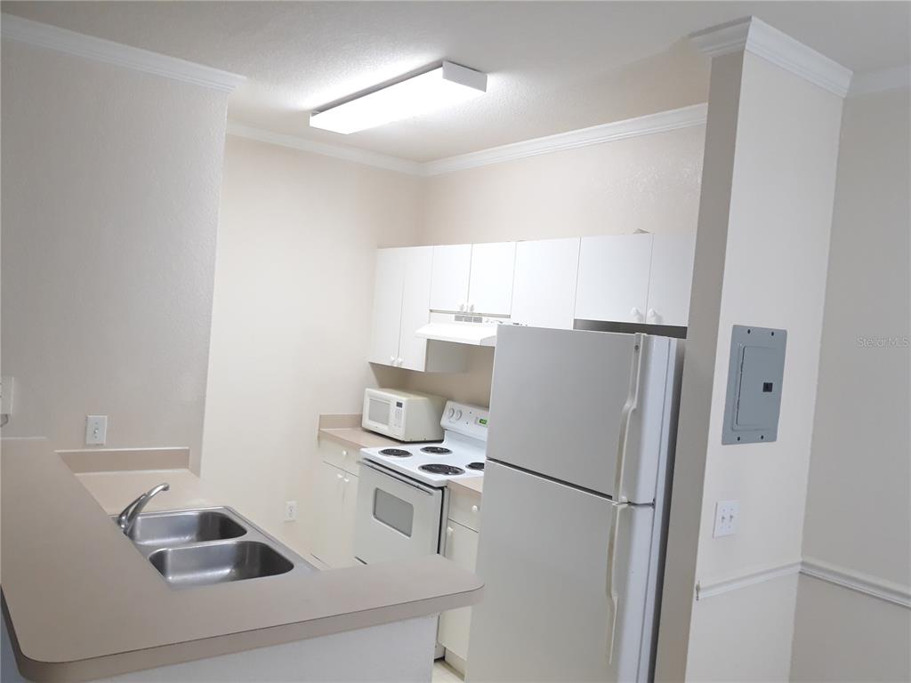 3589 Conroy Road, Unit 1021 Orlando, FL 32839 - Photo 4 of 13 a white refrigerator freezer sitting inside of a kitchen