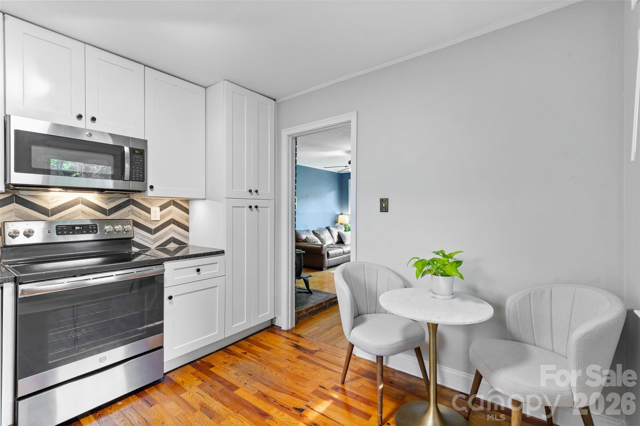 1638 Academy Street Charlotte, NC 28205 - Photo 6 of 30 a kitchen with stainless steel appliances a stove a table and chairs in it