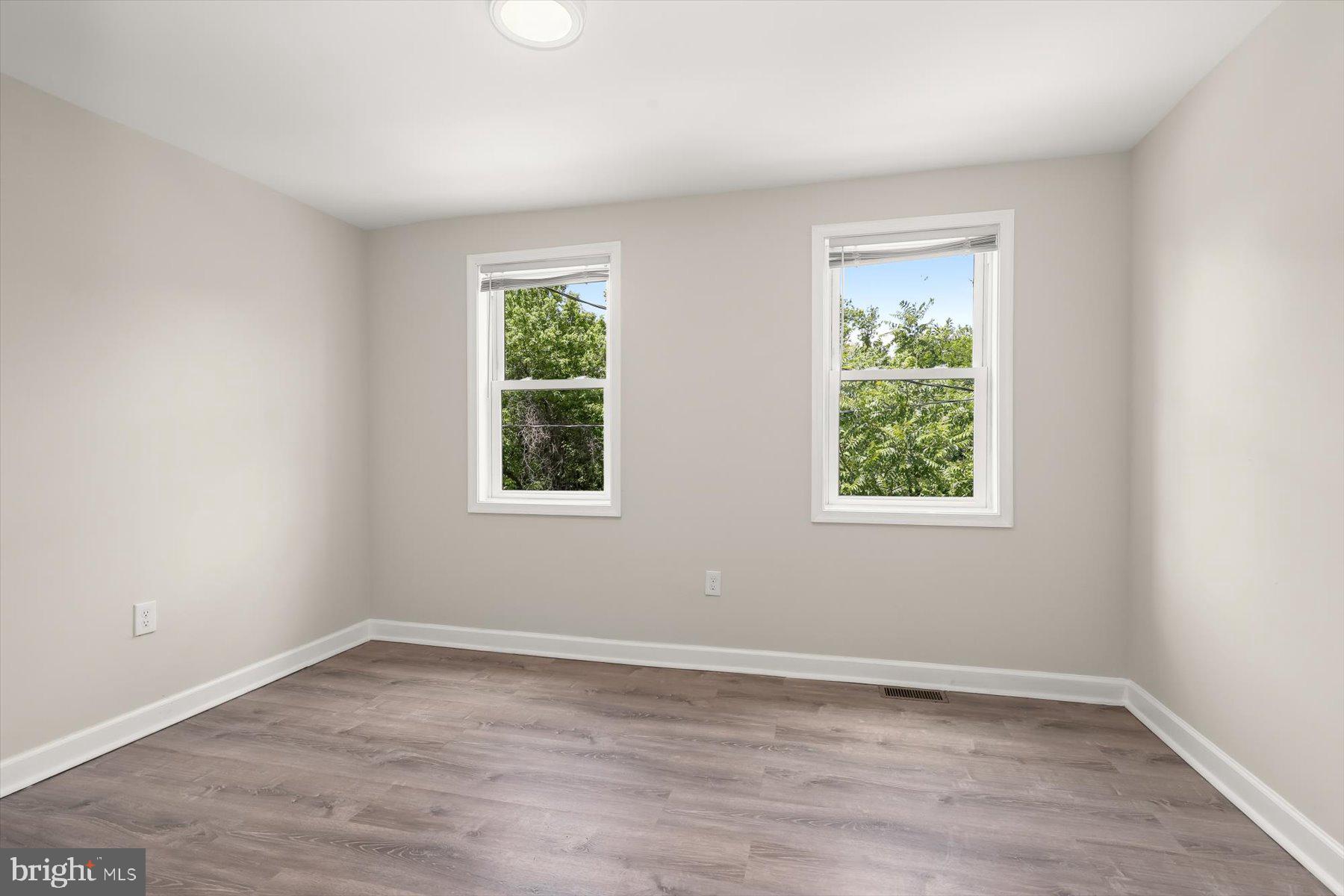 1044 Ellicott Driveway Baltimore, MD 21216 - Photo 10 of 26 an empty room with wooden floor and windows