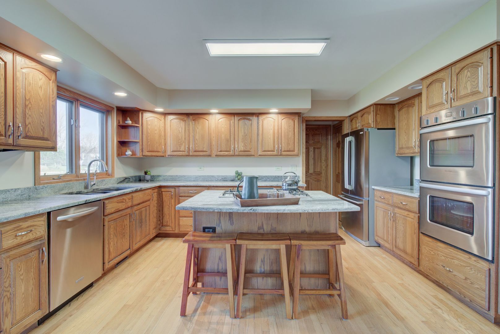 2208 Crystal Circle Crystal Lake, IL 60012 - Photo 12 of 55 a kitchen with granite countertop a stove top oven a sink dishwasher a dining table and chairs with wooden floor