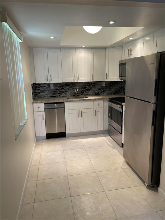 641 Normandy Lane, Unit N Delray Beach, FL 33484 - Photo 3 of 15 a kitchen with granite countertop a refrigerator and a sink