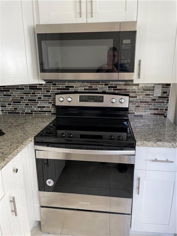 641 Normandy Lane, Unit N Delray Beach, FL 33484 - Photo 4 of 15 a stove top oven sitting inside of a kitchen